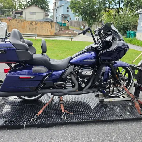 Blue Harley-Davidson Road Glide secured with ratchet straps on the carrier deck